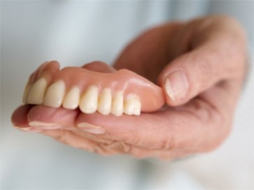 person holding dentures